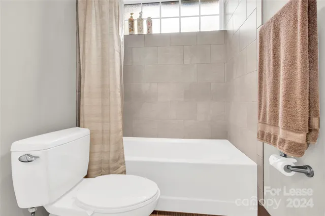 a white toilet sitting next to a bath tub