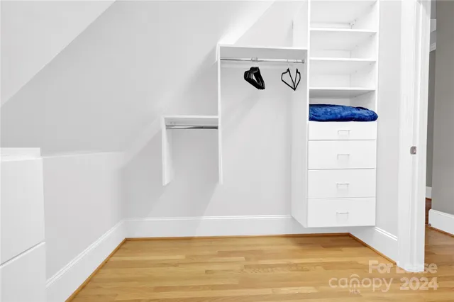 a view of walk in closet with clothes