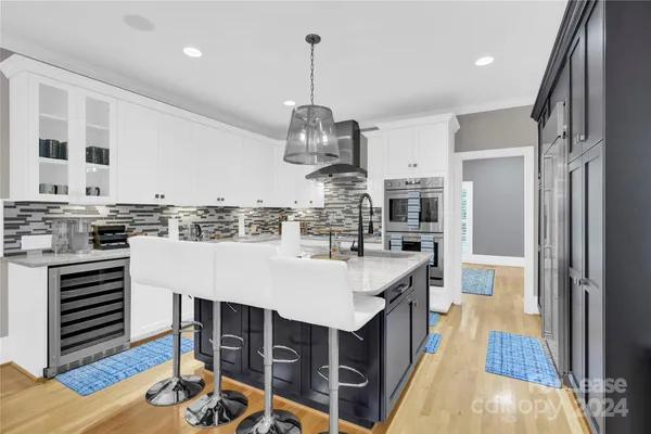 a kitchen with kitchen island granite countertop a table chairs stove and cabinets
