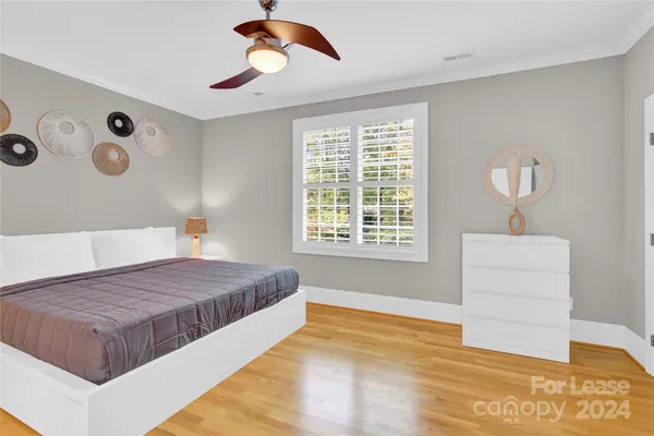 a spacious bedroom with a bed and a dresser