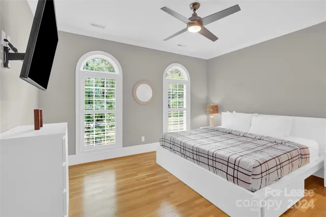 a bedroom with a large bed and a flat screen tv