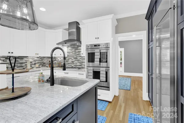 a kitchen with stainless steel appliances granite countertop a sink and a refrigerator