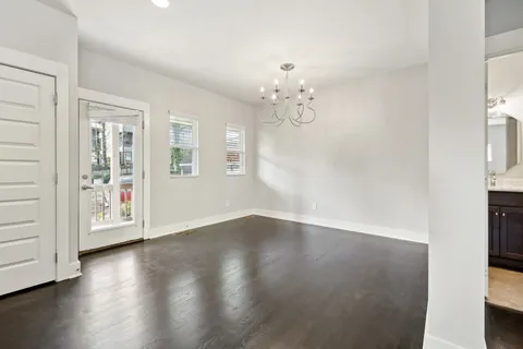 an empty room with wooden floor and window