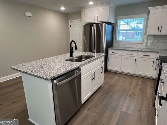 a kitchen with granite countertop white cabinets and appliances