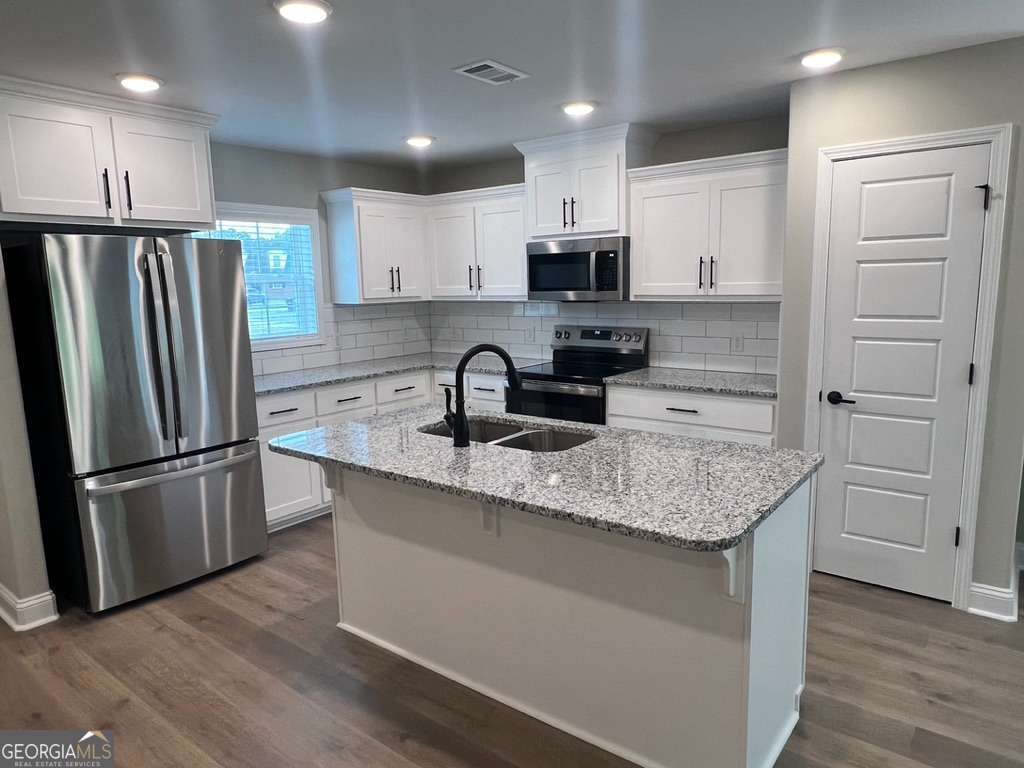 405 Madison Avenue St. Marys, GA 31558 - Photo 3 of 21 a kitchen with kitchen island granite countertop stainless steel appliances a refrigerator a sink and cabinets