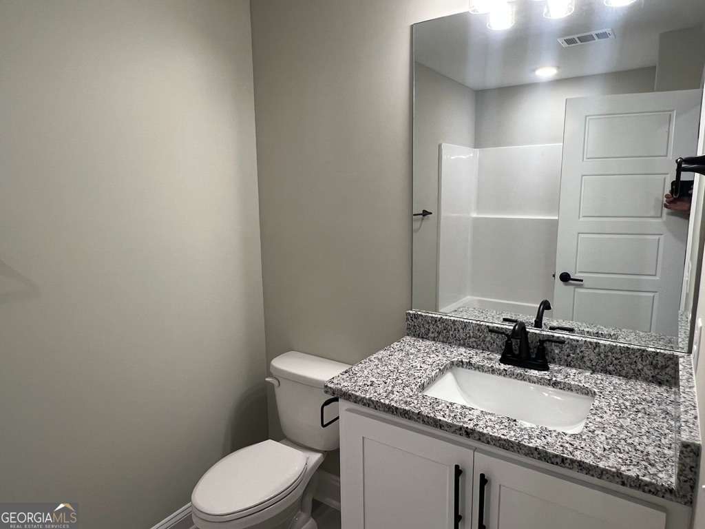 405 Madison Avenue St. Marys, GA 31558 - Photo 7 of 21 a bathroom with a granite countertop sink toilet and a mirror