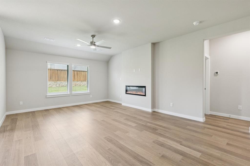 1468 Companero Street Haslet, TX 76052 - Photo 10 of 29 an empty room with wooden floor chandelier and windows