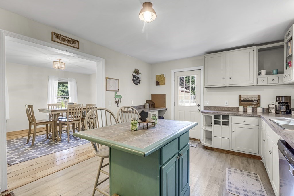 24 Sand Hill Road Salisbury, MA 01952 - Photo 3 of 28 a kitchen with a stove a sink a dining table and chairs