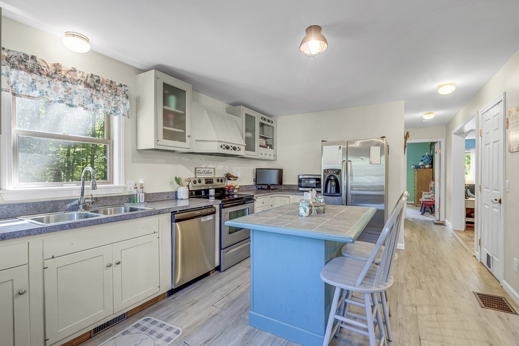 24 Sand Hill Road Salisbury, MA 01952 - Photo 7 of 28 a kitchen with granite countertop a sink stove refrigerator dining table and chairs