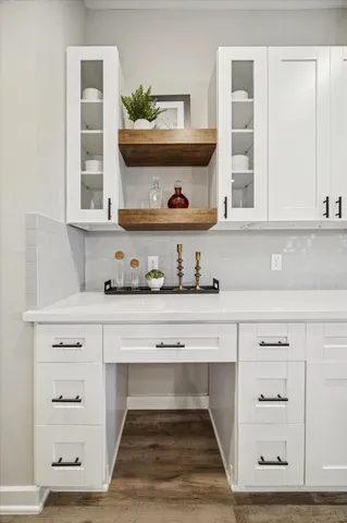 a living room with white cabinets and a wooden floor