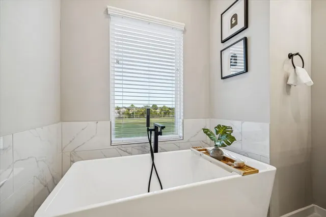 a bath tub sitting in a bathroom next to a window