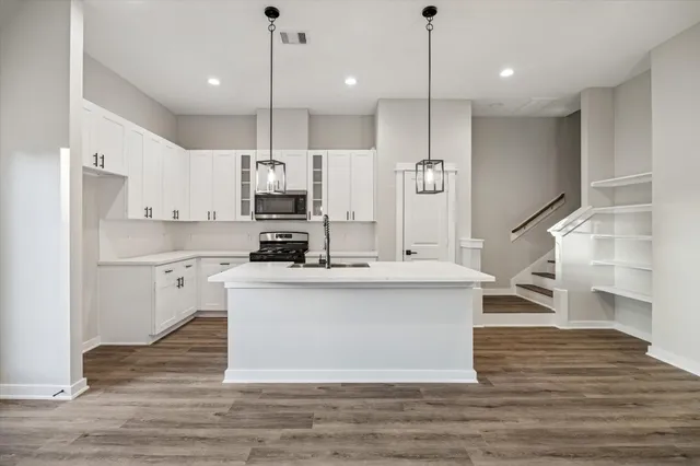 a kitchen with stainless steel appliances granite countertop a sink a stove and a refrigerator