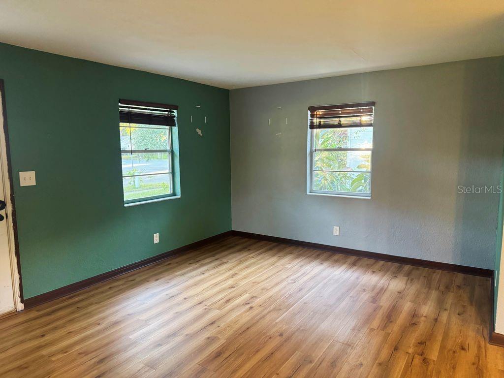 1030 East Walnut Street Lakeland, FL 33801 - Photo 3 of 11 a view of an empty room with wooden floor and a window