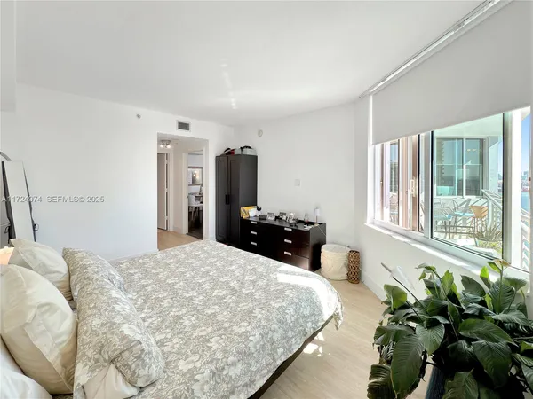 a bed room with a bed mirror and a potted plant