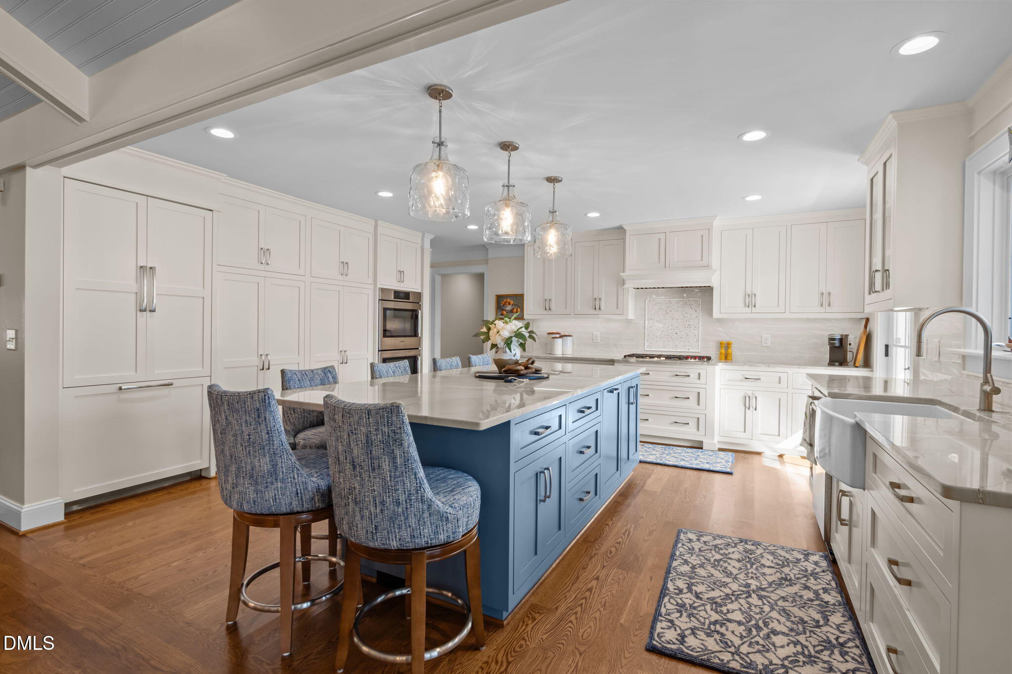 515 Oak Pointe Drive Semora, NC 27343 - Photo 23 of 66 a large kitchen with granite countertop lots of white cabinets a sink dishwasher a dining table and chairs with wooden floor