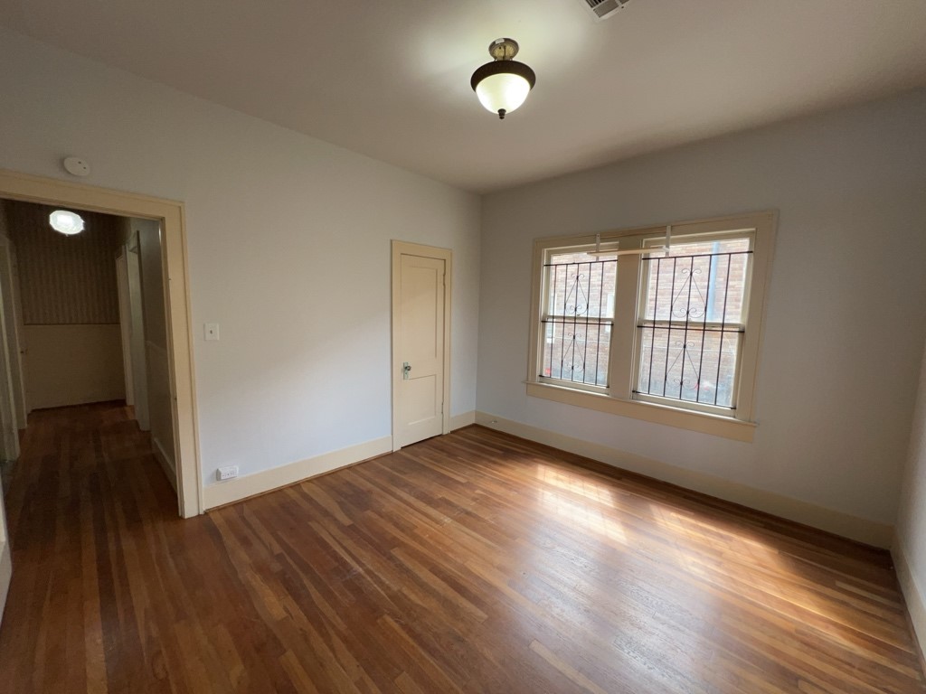 4716 Crawford Street Houston, TX 77004 - Photo 8 of 15 an empty room with wooden floor and windows