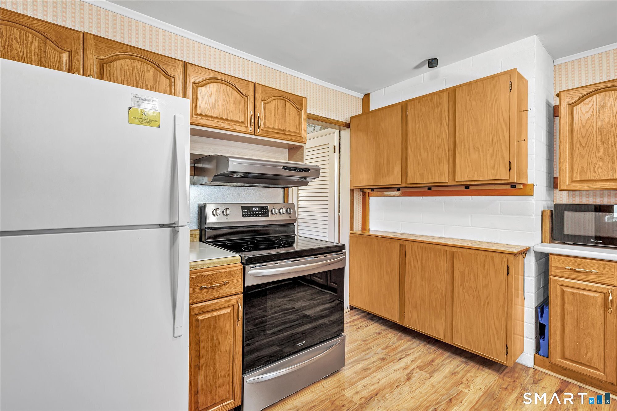 61 Soundview Avenue Shelton, CT 06484 - Photo 12 of 33 a kitchen with stainless steel appliances a stove a microwave and a refrigerator