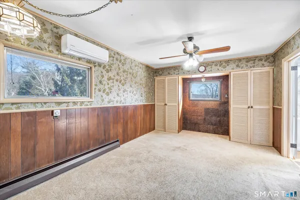 a view of a hallway with a chandelier fan and wooden floor