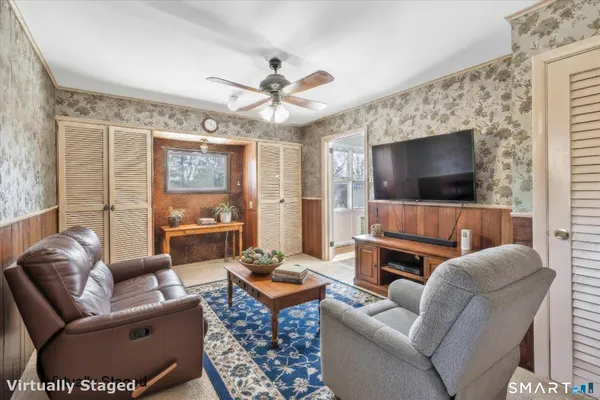 a living room with furniture a flat screen tv and a large window