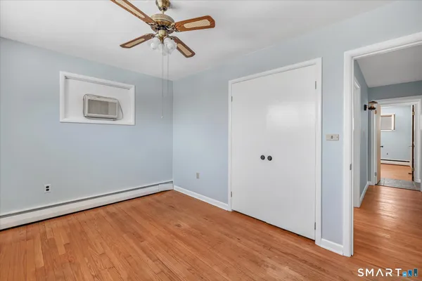 a view of empty room with wooden floor