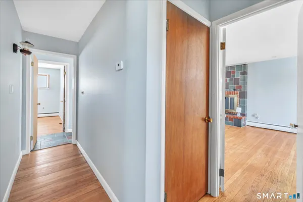 a view of a hallway with wooden floor and closet