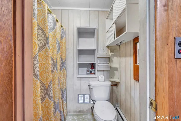 a white toilet sitting next to a shower curtain