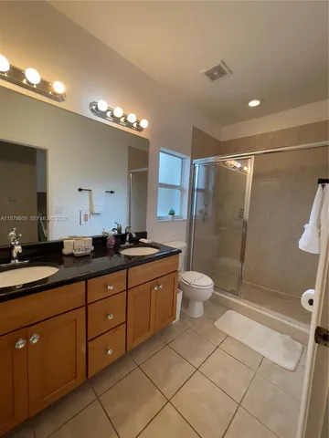 a bathroom with a shower a toilet and a glass door