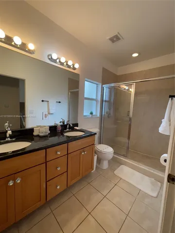 a bathroom with a double vanity sink toilet and shower