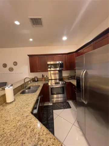 a kitchen with refrigerator and chairs