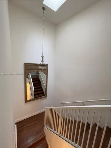 a view of a hallway with wooden floor and a window