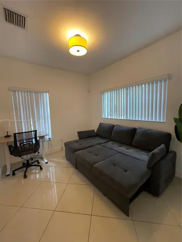 a living room with furniture and a lamp