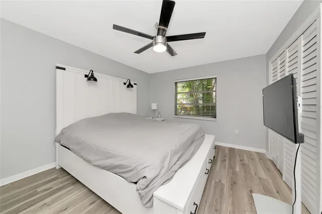 a room with a bed and a flat tv screen on dresser