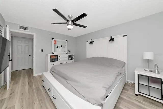 a spacious bedroom with a bed and a chandelier