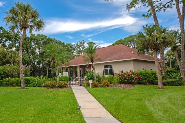 a view of a patio with table and chairs and floor to ceiling window with garden