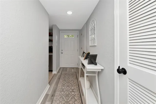 a view of a hallway with furniture and a window