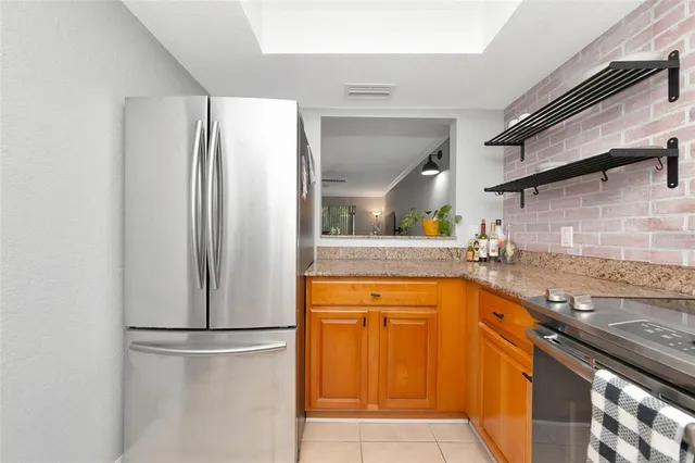 a kitchen with stainless steel appliances granite countertop a refrigerator and a sink