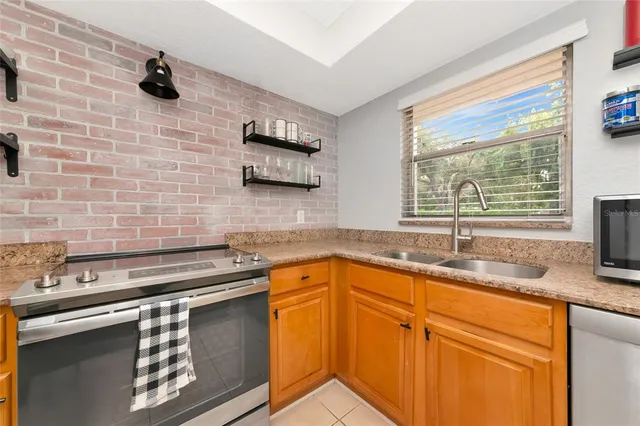 a kitchen with stainless steel appliances granite countertop a sink a stove a granite counter tops and a window