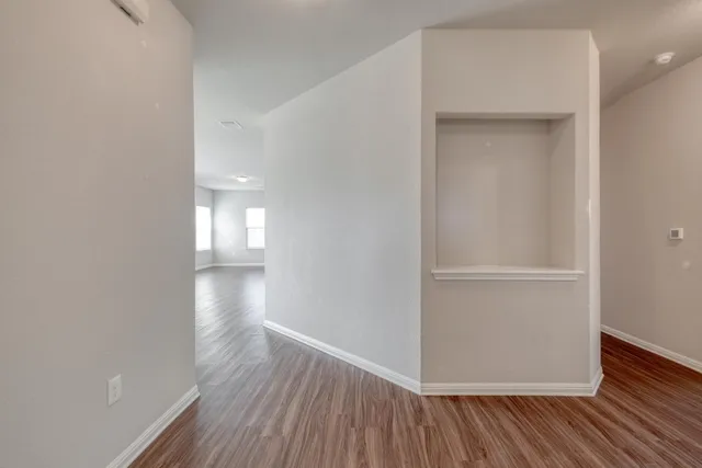 a view of an empty room with wooden floor