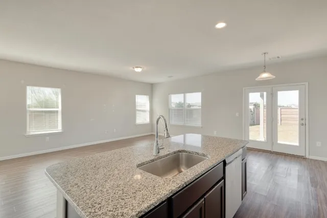 a kitchen with granite countertop a sink and dishwasher with wooden floor