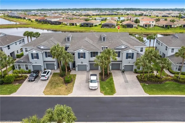 an aerial view of residential houses with outdoor space and ocean view