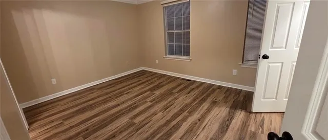 a view of a room with wooden floor and a window