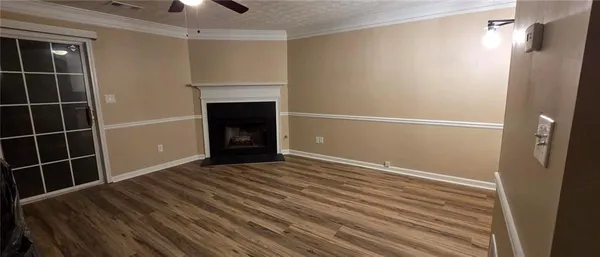 a view of an empty room with wooden floor and a cabinet