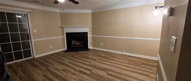 a view of an empty room with wooden floor and a cabinet