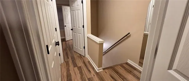 a view of a hallway with wooden floor and staircase
