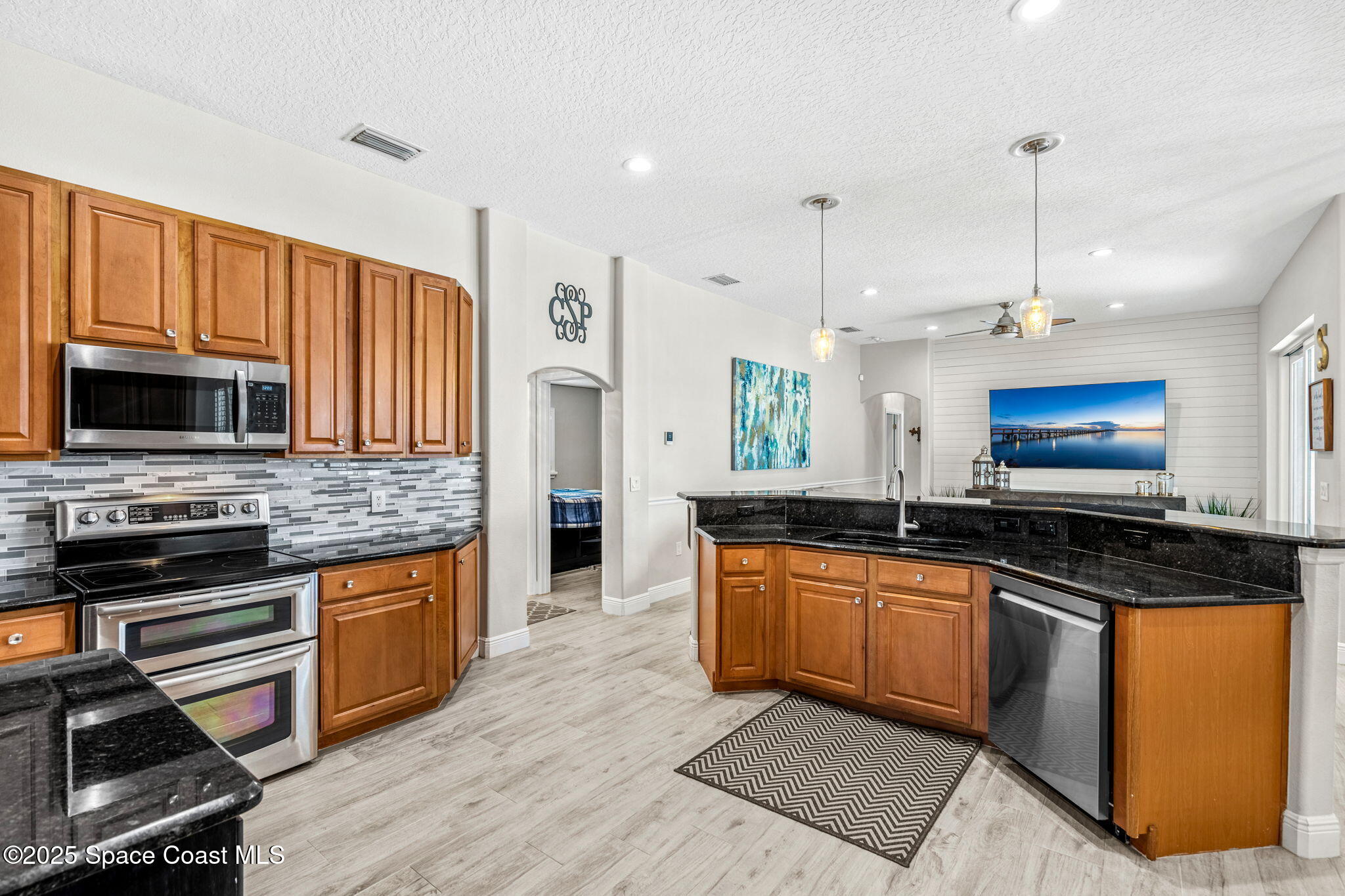 4440 Chardonnay Drive Rockledge, FL 32955 - Photo 22 of 41 a kitchen with stainless steel appliances granite countertop a stove top oven a sink dishwasher a dining table and chairs with wooden floor