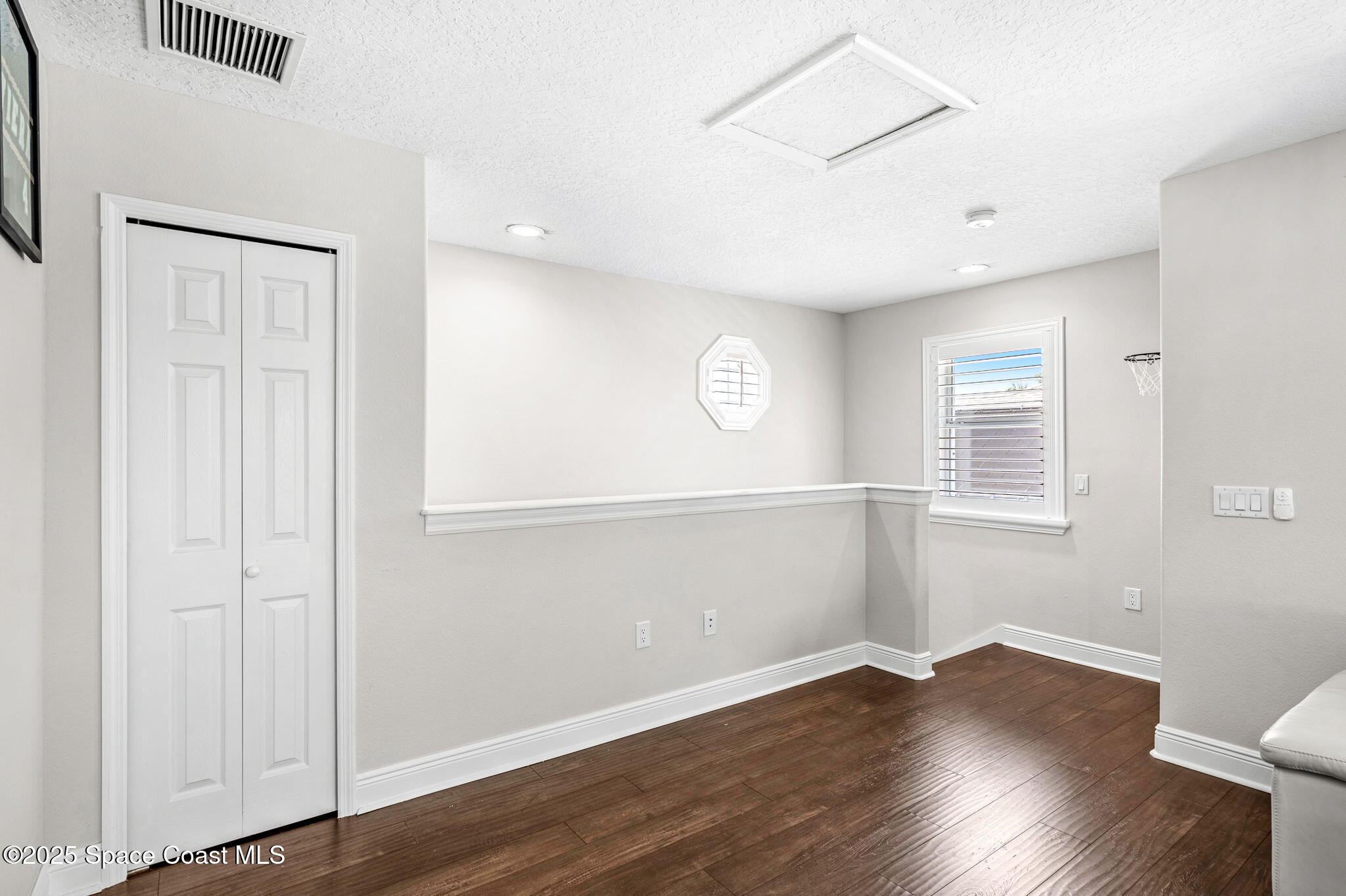 4440 Chardonnay Drive Rockledge, FL 32955 - Photo 24 of 41 an empty room with wooden floor and windows