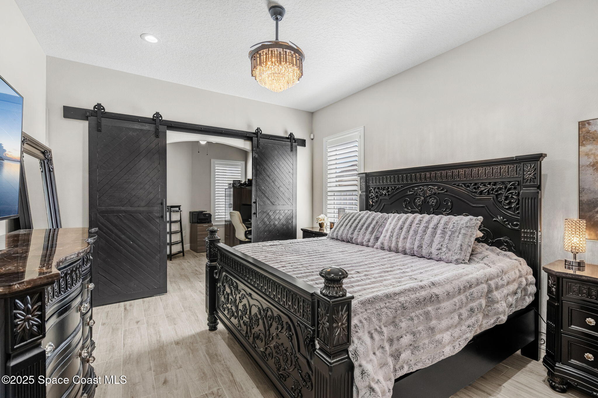 4440 Chardonnay Drive Rockledge, FL 32955 - Photo 26 of 41 a bedroom with a bed a table and flat screen tv