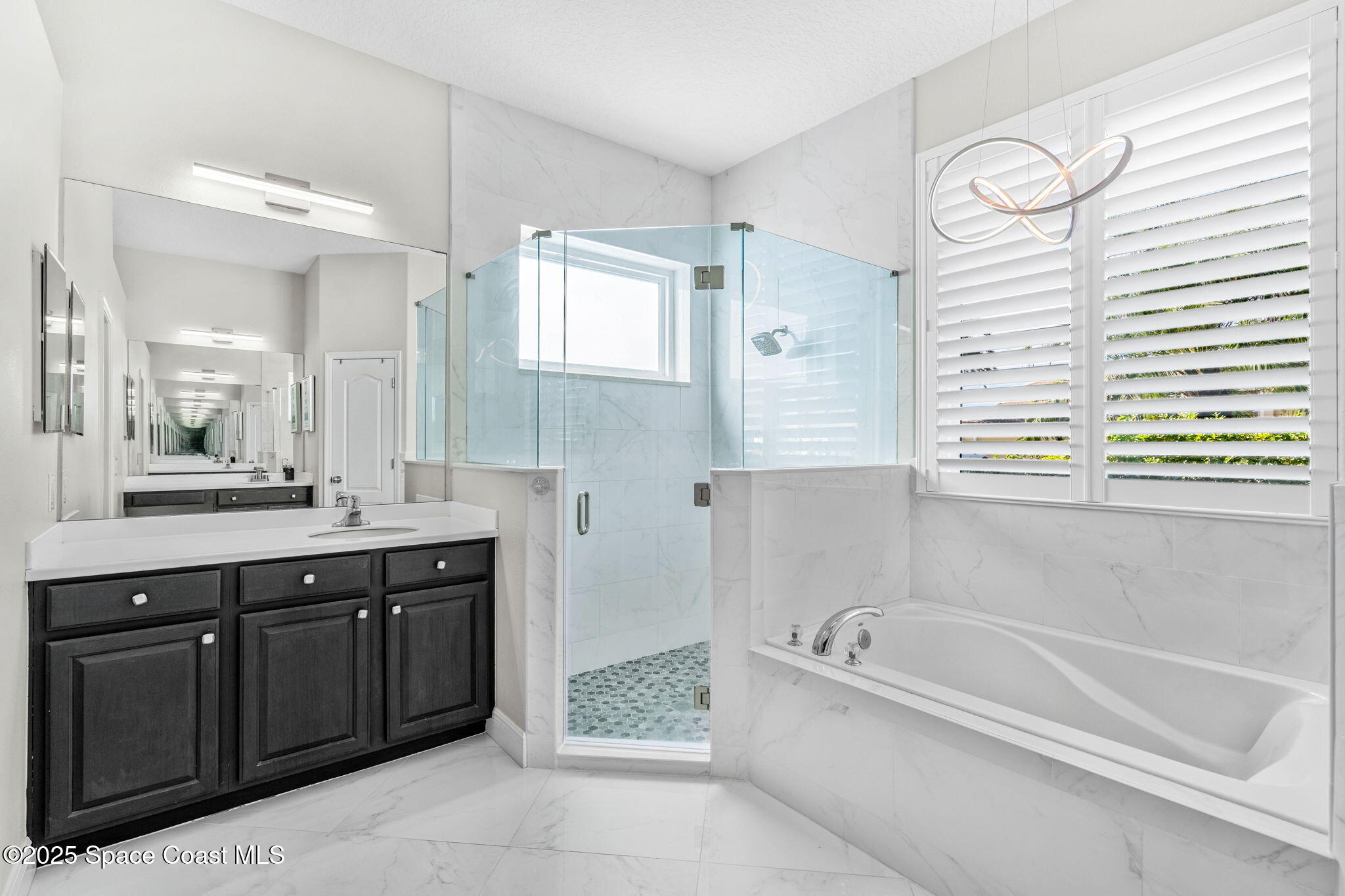 4440 Chardonnay Drive Rockledge, FL 32955 - Photo 28 of 41 a spacious bathroom with a tub sink and mirror