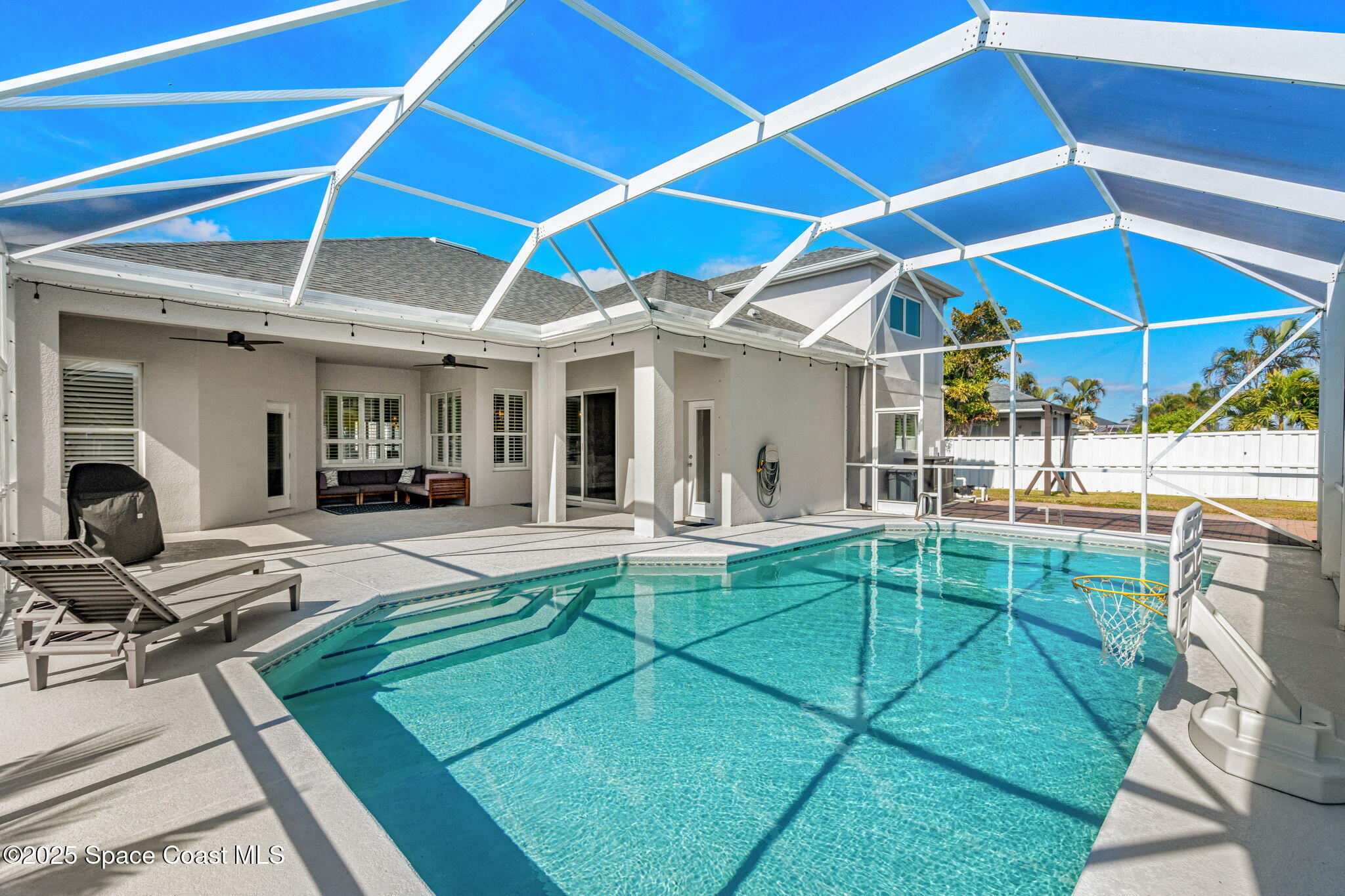 4440 Chardonnay Drive Rockledge, FL 32955 - Photo 35 of 41 a view of a backyard with swimming pool table and chairs under an umbrella