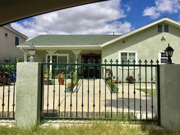 a view of a house with a floor to ceiling window and a yard